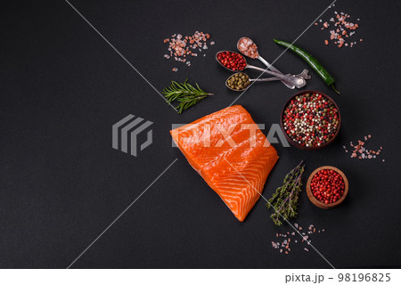 Fillet of raw red salmon fish with salt, spices and herbs 98196825