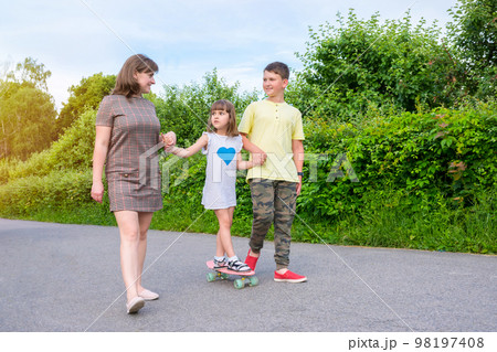 Mom with children plays in the park. Active lifestyle, family weekend Mom with children plays in the park. Active lifestyle, family weekend 98197408