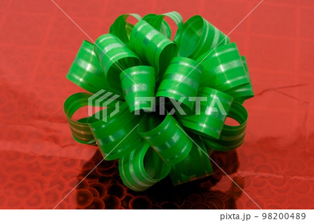 Green bow on red festive surface 98200489