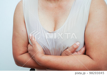 Asian woman self touching check lump or Breast cancer, Breast Self Exam. . 98203045