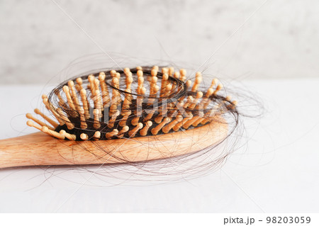 Hair loss fall with comb brush isolated on white background. Hair loss fall with comb brush isolated on white background. 98203059