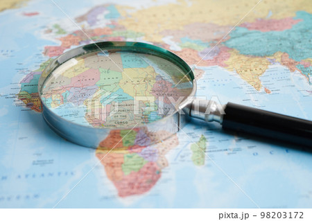 Bangkok, Thailand - May 15, 2022 Magnifying glass on world map. Bangkok, Thailand - May 15, 2022 Magnifying glass on world map. 98203172