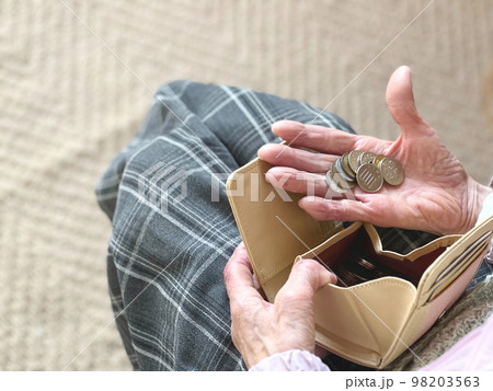 財布から出した小銭を手の平にのせた高齢女性 98203563