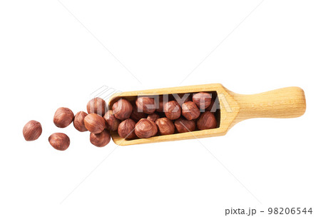 Pile of shelled hazelnut kernels in wooden scoop on white background. Top view. Pile of shelled hazelnut kernels in wooden scoop on white background. Top view. 98206544