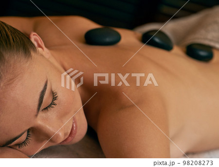 Being pampered from top to toe. A young woman lying with her eyes closed on a massage bed. 98208273