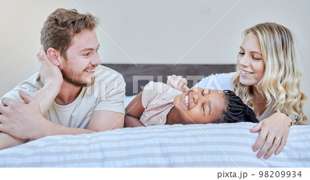 Family, adoption and love with happy, smile and care together on bed, relax and fun on weekend in home. Diversity, bedroom and happiness with bonding, support and relaxing with moth, father and girl Family, adoption and love with happy, smile and care together on bed, relax and fun on weekend in home. Diversity, bedroom and happiness with bonding, support and relaxing with moth, father and girl 98209934