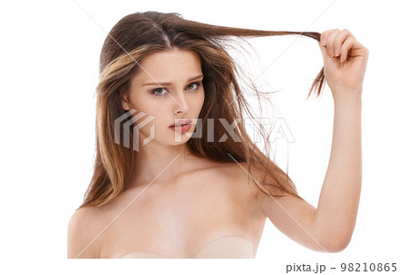 Portrait, hair and fail with a model woman in studio on a white background holding split ends in frustration. Face, haircare and unhappy with a young female feeling negative about her hairstyle 98210865