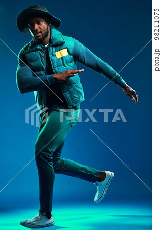 Fashion, neon and portrait of black man on blue background with cool, trendy and stylish outfit. Creative style, urban clothing and male fashion model in studio with designer, modern and edgy clothes 98211075