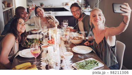 Selfie, dinner and party with friends eating food together for a new year celebration or event. Home, feast and meal with a man and woman friend group sitting at a table for a social gathering Selfie, dinner and party with friends eating food together for a new year celebration or event. Home, feast and meal with a man and woman friend group sitting at a table for a social gathering 98211306