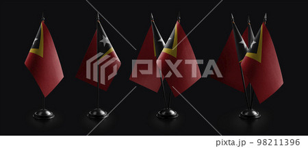 Small national flags of the East Timor on a black background 98211396