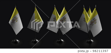 Small national flags of the Vatican on a black background 98211397