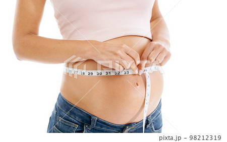 Pregnancy, measuring tape and woman stomach in studio to check growth, development and health on mockup. Abdomen, wellness and pregnant woman self care, diet and healthy progress on white background 98212319