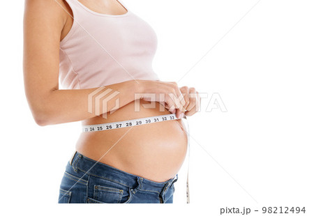 Pregnant woman, measuring tape and stomach on a white background to check growth, development and health. Abdomen, wellness and pregnancy for self care, diet and healthy progress goals on mock up 98212494