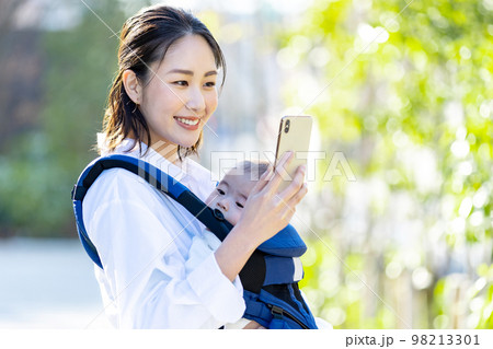 抱っこ紐で育児をする若い女性 98213301