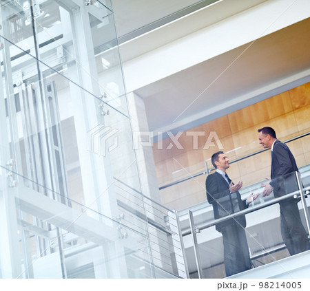 Business men, talking and networking with communication, meeting and collaboration on balcony at airport or office. Partnership, business meeting or travel with b2b, conference and corporate strategy 98214005