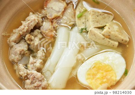 large rice noodles slice sausage with chop and crispy pork topping soft boiled egg in soup on bowl large rice noodles slice sausage with chop and crispy pork topping soft boiled egg in soup on bowl 98214030