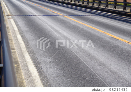 融雪剤の粉末で白くなったアスファルト路面 98215452