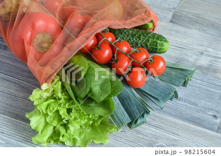 High angle view many vegetables in reusable mesh bag on table indoors High angle view many vegetables in reusable mesh bag on table indoors 98215604