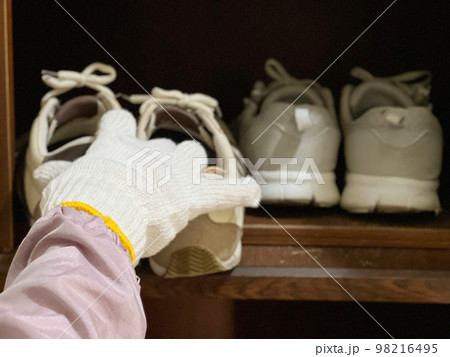 靴箱から靴を取り出す軍手をした手 靴箱から靴を取り出す軍手をした手 98216495