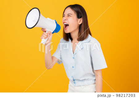 Woman holding megaphone with fists clenched celebrating victory expressing success 98217203