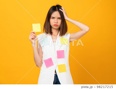 Boring young Asian woman holding sticky note, stand on studio shot yellow background. 98217215