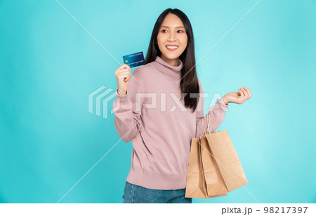 Beautiful Asian woman holding brown blank craft paper shopping bags and showing credit card Beautiful Asian woman holding brown blank craft paper shopping bags and showing credit card 98217397