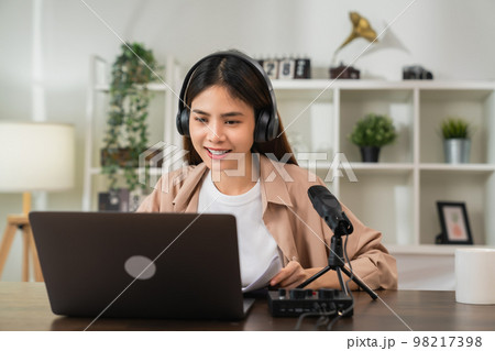 woman wearing headphones and using laptop at video calling meeting and study online woman wearing headphones and using laptop at video calling meeting and study online 98217398