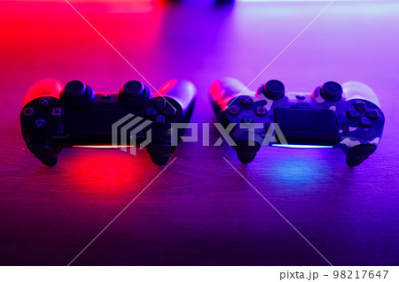 Gamepad on a wooden table with backlight. Gamepad on a wooden table with backlight. 98217647