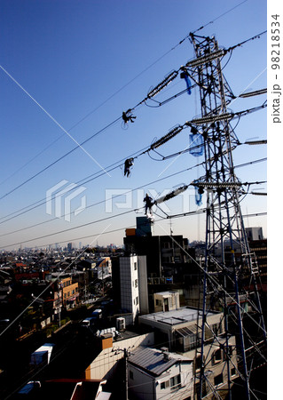 都内杉並区から新宿方面を望む、鉄塔、送電線と電気を守る男たち 98218534