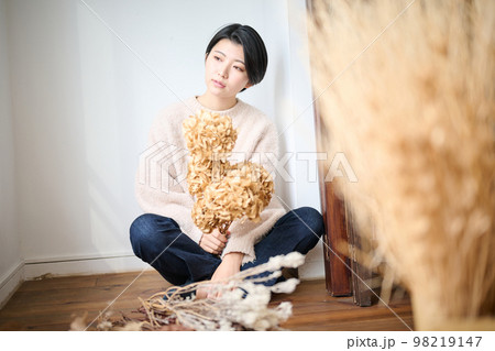 ドライフラワーを持つ女性ポートレート 98219147