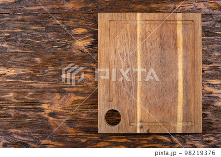 Empty old cutting board on a wooden background. Layout for the recipe. Empty old cutting board on a wooden background. Layout for the recipe. 98219376