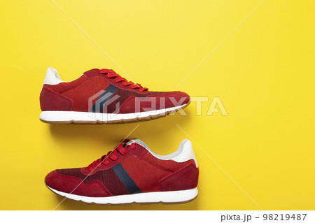 New unbranded running sneaker or trainer on yellow background. Men's sport footwear. 98219487