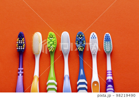 Toothbrushes on a orange background. Concept toothbrush selection. Oral cavity care. Dental hygiene. 98219490