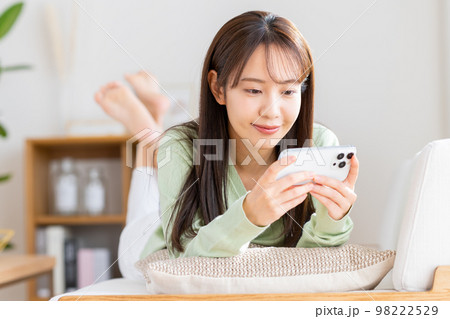 リビングでスマホを見る若い女性 リビングでスマホを見る若い女性 98222529