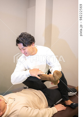 男性のスポーツインストラクターによる柔軟ストレッチ 98222569