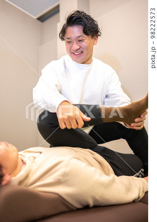 男性のスポーツインストラクターによる柔軟ストレッチ 98222573