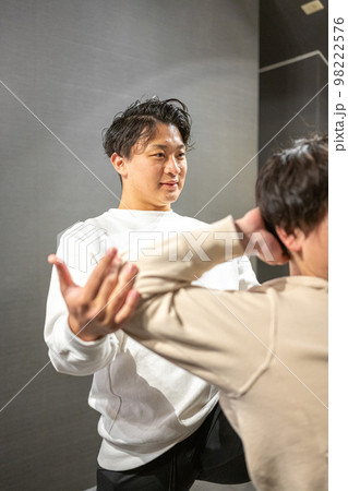 男性のスポーツインストラクターによる柔軟ストレッチ 98222576