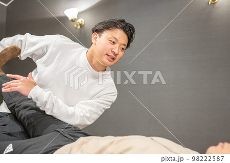 男性のスポーツインストラクターによる柔軟ストレッチ 98222587