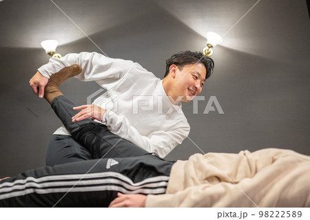 男性のスポーツインストラクターによる柔軟ストレッチ 98222589
