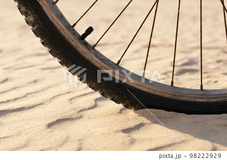 Bicycle wheel on the sand in the desert close up Bicycle wheel on the sand in the desert close up 98222929