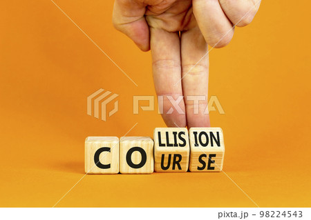 Collision course symbol. Concept word Collision course on wooden cubes. Beautiful orange table orange background. Businessman hand. Business collision course concept. Copy space. 98224543