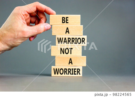 Warrior or worrier symbol. Concept words Be a warrior not a worrier on wooden blocks on a beautiful grey table grey background. Businessman hand. Business warrior or worrier concept. 98224565