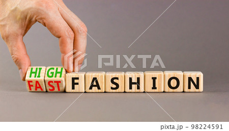 Fast or high fashion symbol. Concept words Fast fashion and High fashion on wooden cubes. Businessman hand. Beautiful grey table grey background. Business fast or high fashion concept. Copy space. 98224591