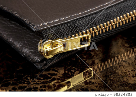 Part of a leather wallet with a zipper. Part of a leather wallet with a zipper. 98224802