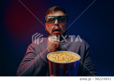 A man watches horror movies. The emotion of fear. A man watches horror movies. The emotion of fear. 98224841