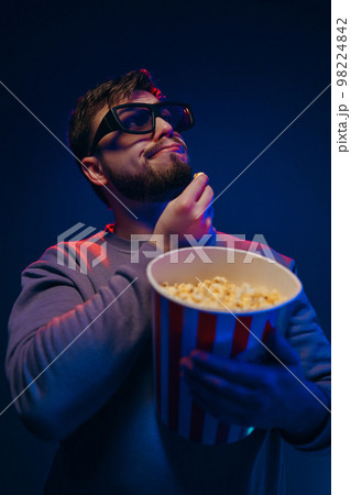 A guy in 3 glasses is watching a movie. Waiting for the premiere. A guy in 3 glasses is watching a movie. Waiting for the premiere. 98224842