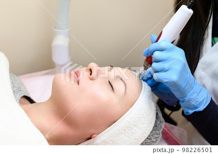 A beautician performs a rejuvenating mesotherapy procedure using dermapen. 98226501