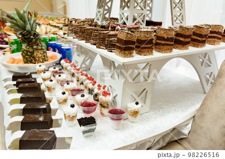 Exquisite festive table with sweets and fruits. 98226516