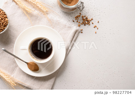Barley coffee in white cup and ears of barley on white background. Barley coffee in white cup and ears of barley on white background. 98227704