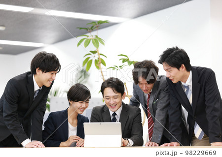 打ち合わせ_PCを見て喜ぶ管理職とビジネスパーソン4人_1 98229669